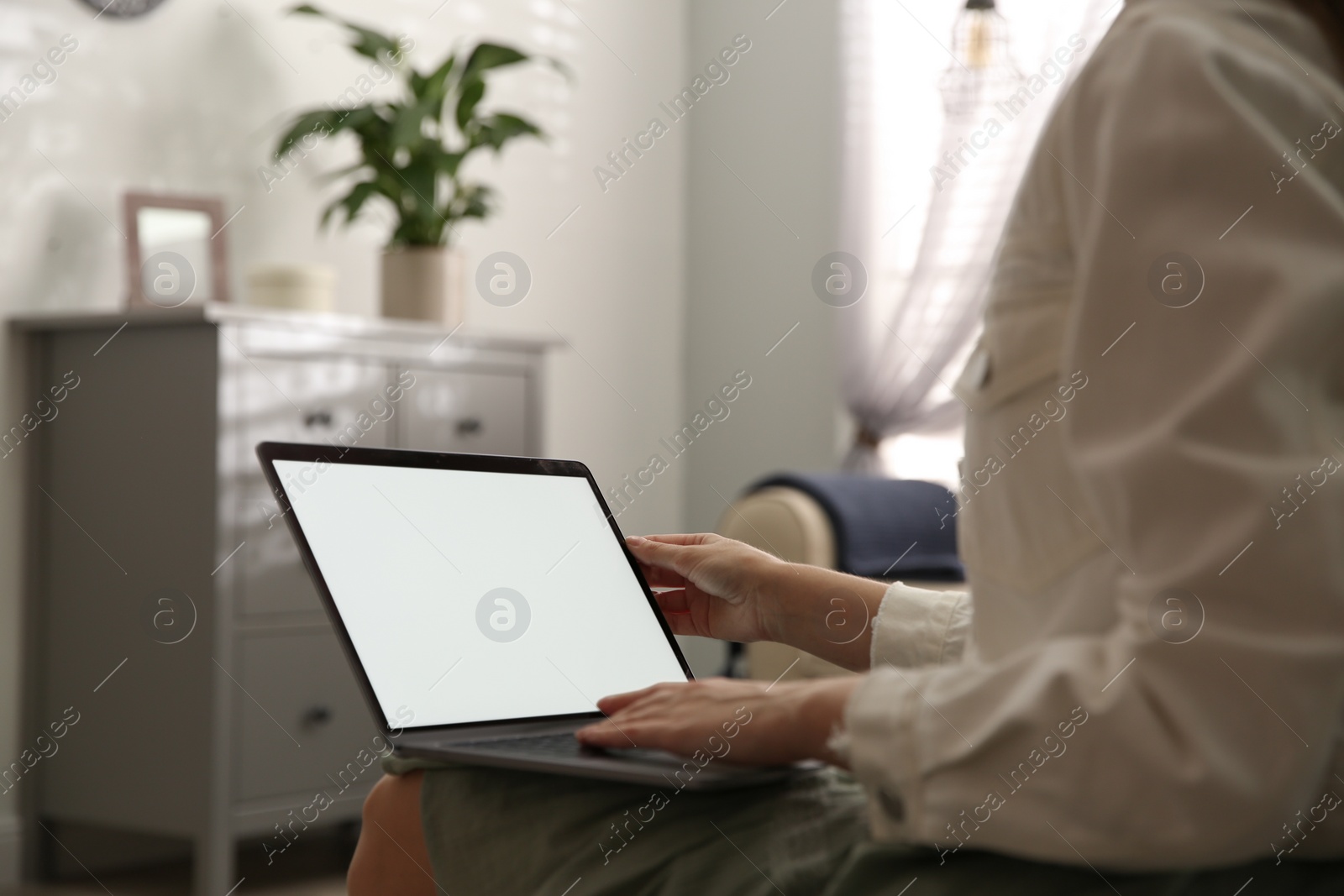 Photo of Woman using laptop at home, closeup. Space for design