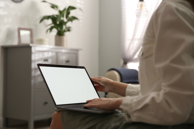 Woman using laptop at home, closeup. Space for design