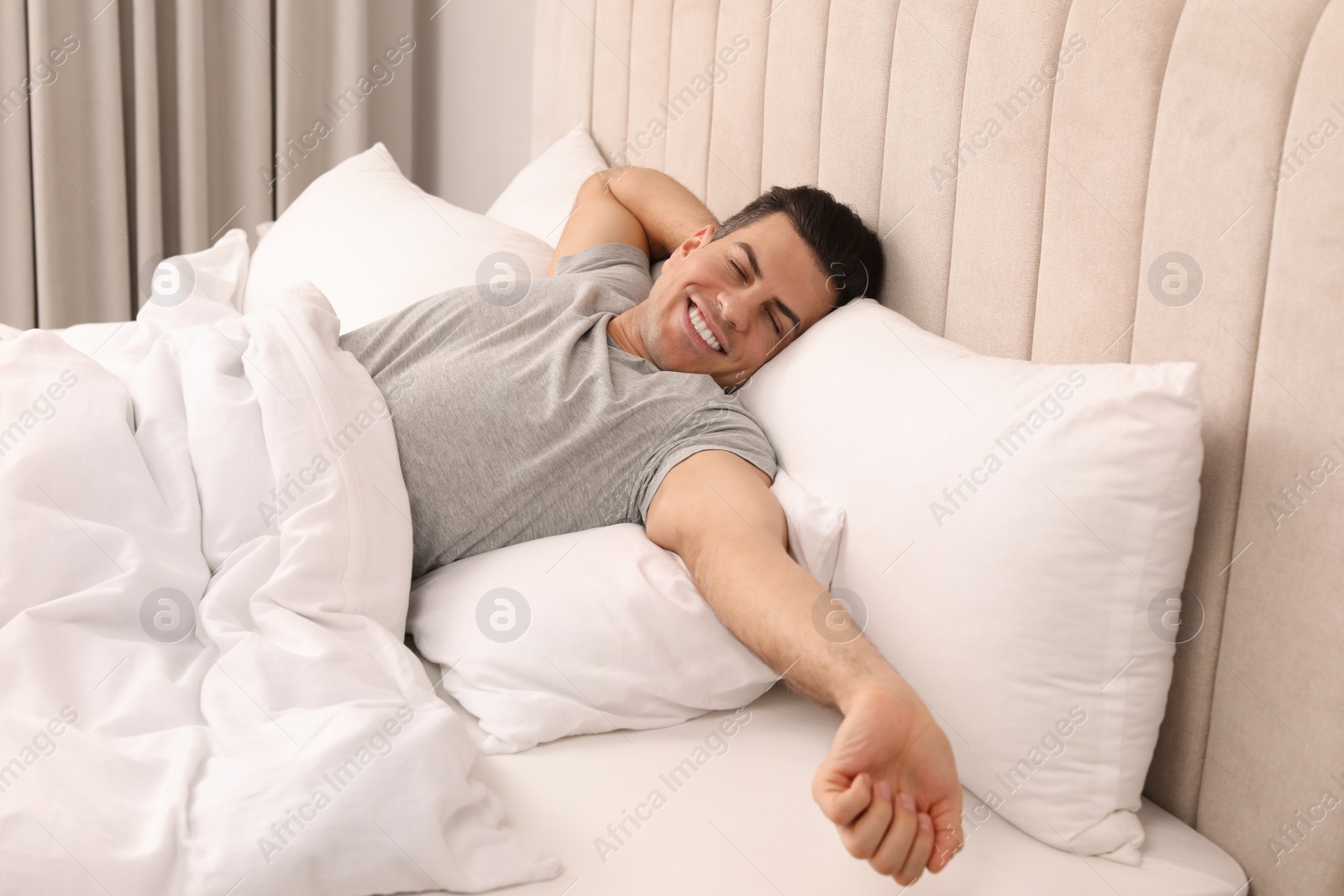 Photo of Happy man awakening in bed at home