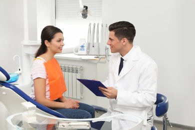 Photo of Professional dentist working with patient in clinic