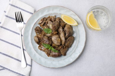 Delicious fried chicken liver with onion served on light table, flat lay