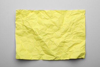 Color sheet of crumpled paper on grey background, top view