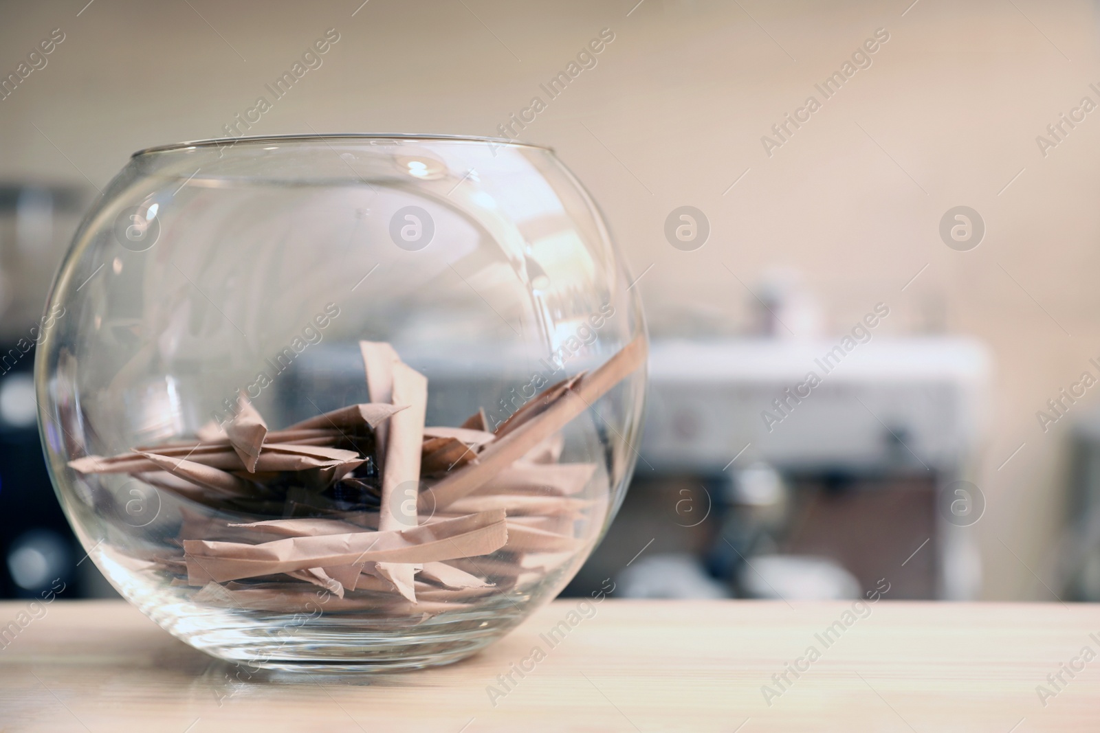 Photo of Bowl with sugar sticks on counter in coffee shop. Space for text