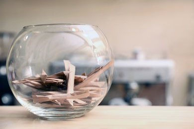 Bowl with sugar sticks on counter in coffee shop. Space for text