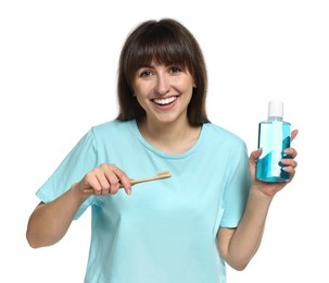 Young woman with mouthwash and toothbrush on white background