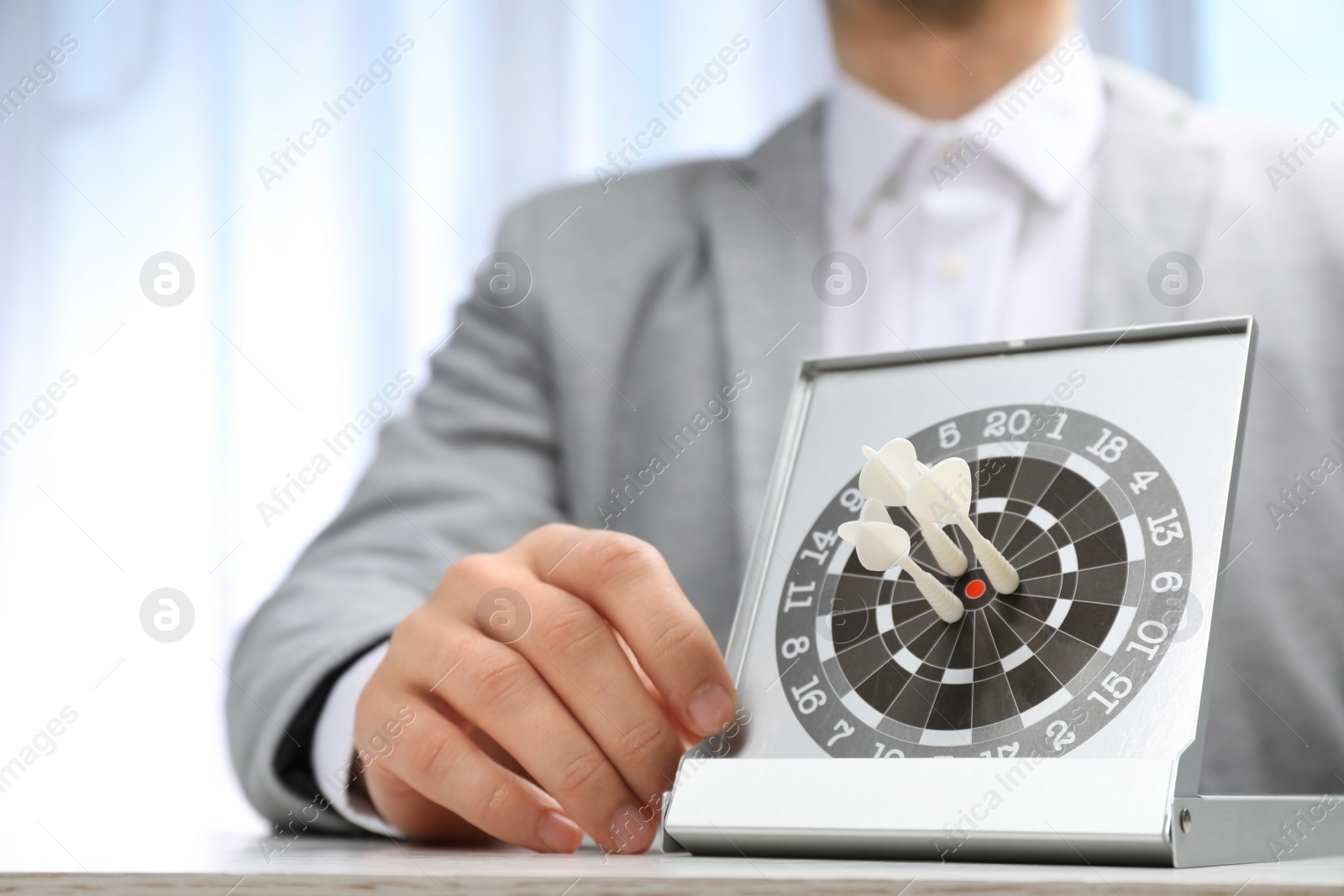 Photo of Man with darts at table. Business trainer concept