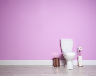 Photo of New ceramic toilet bowl in modern bathroom with space for text