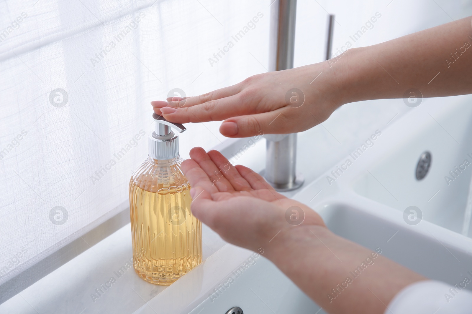 Photo of Woman washing hands with liquid soap at home, closeup