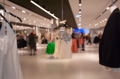 Photo of Blurred view of modern boutique interior with stylish clothes