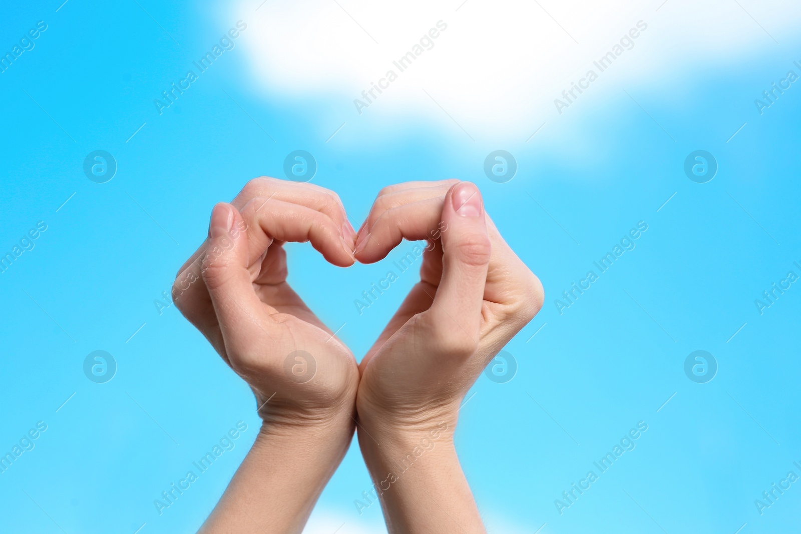 Photo of Woman making heart with her hands on color background, closeup