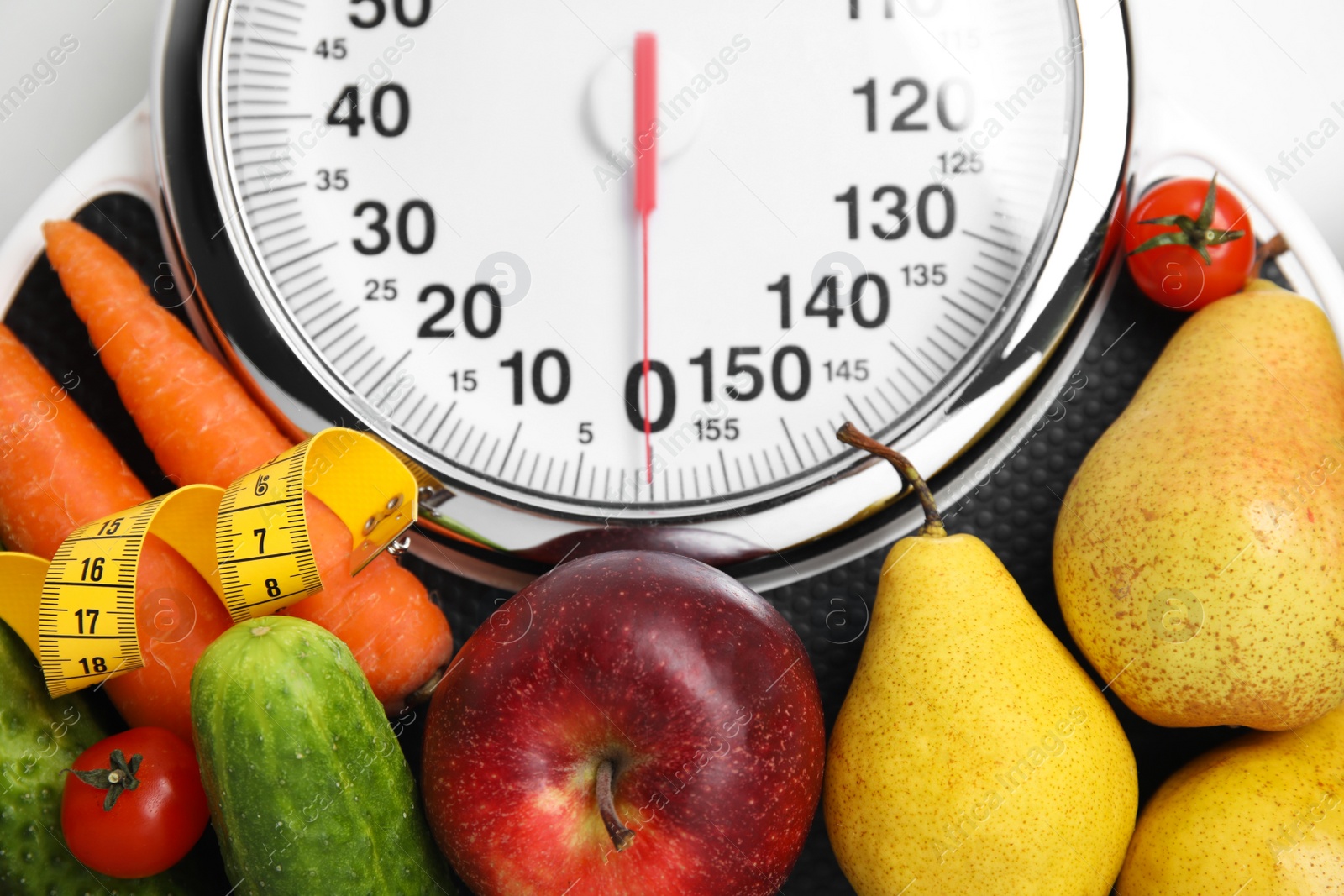 Scales, healthy food and measuring tape on white table, top view Photo of Scales, healthy food and measuring tape on white table, top view