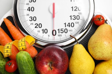 Photo of Scales, healthy food and measuring tape on white table, top view