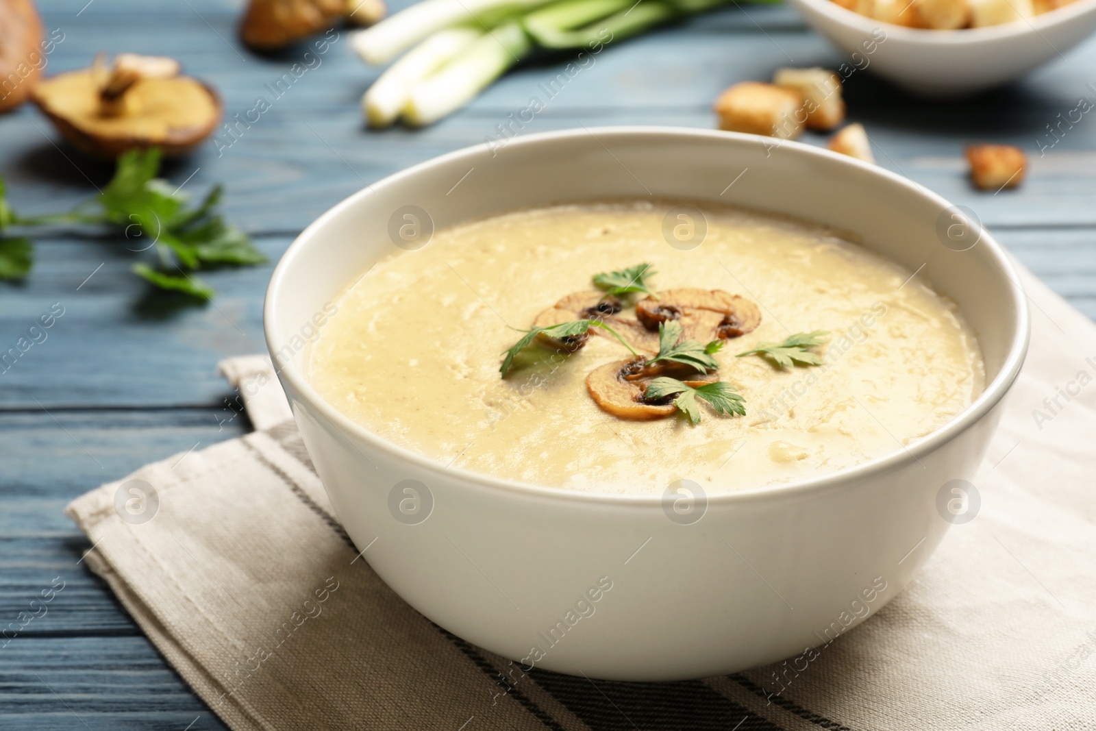 Photo of Bowl of fresh homemade mushroom soup on wooden table