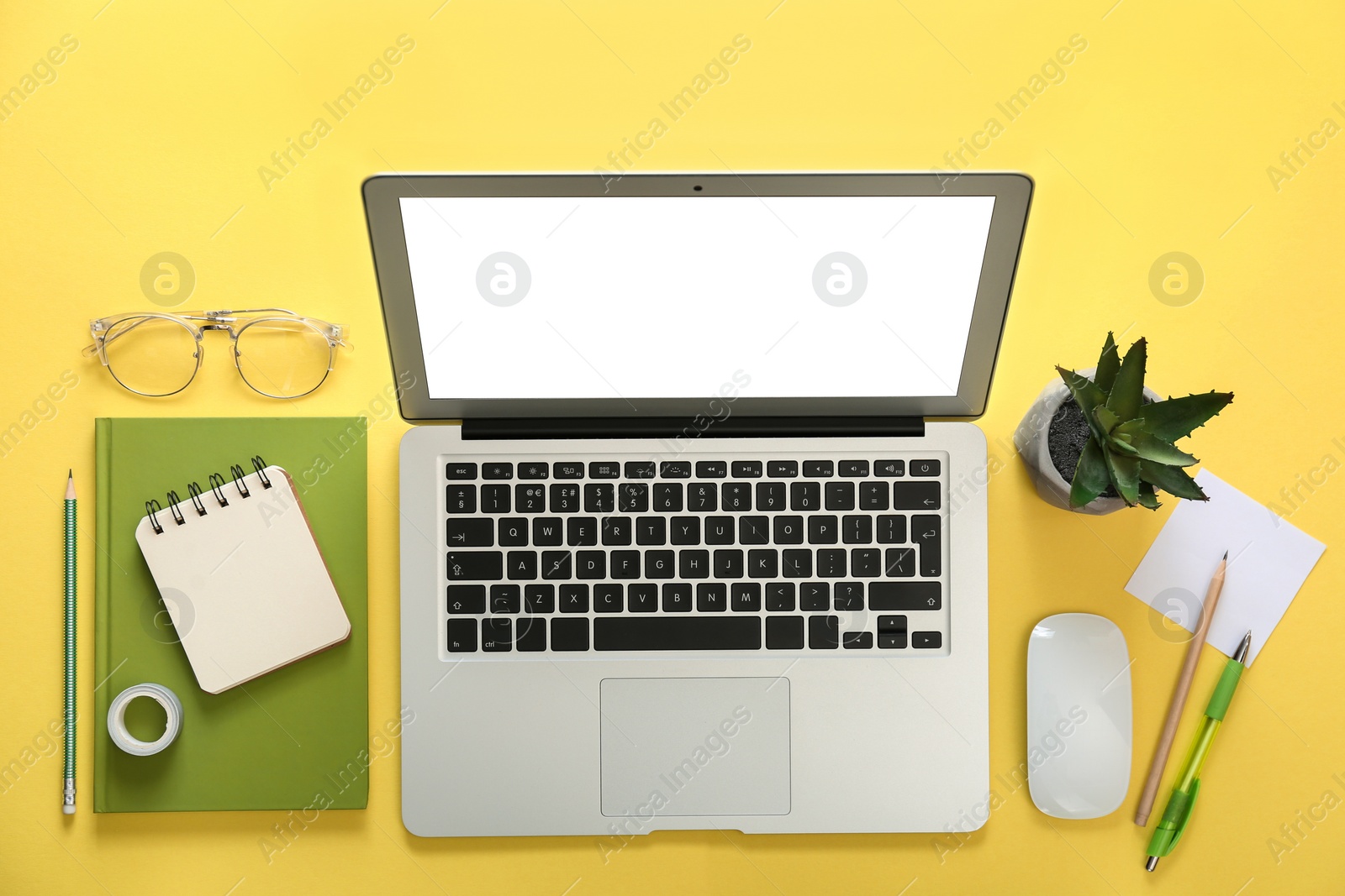 Photo of Laptop and office stationery on yellow background, flat lay