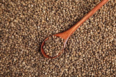 Photo of Wooden spoon and hemp seeds, top view