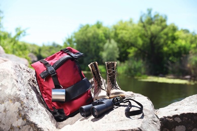 Photo of Traveling gear on rock near river. Summer camp