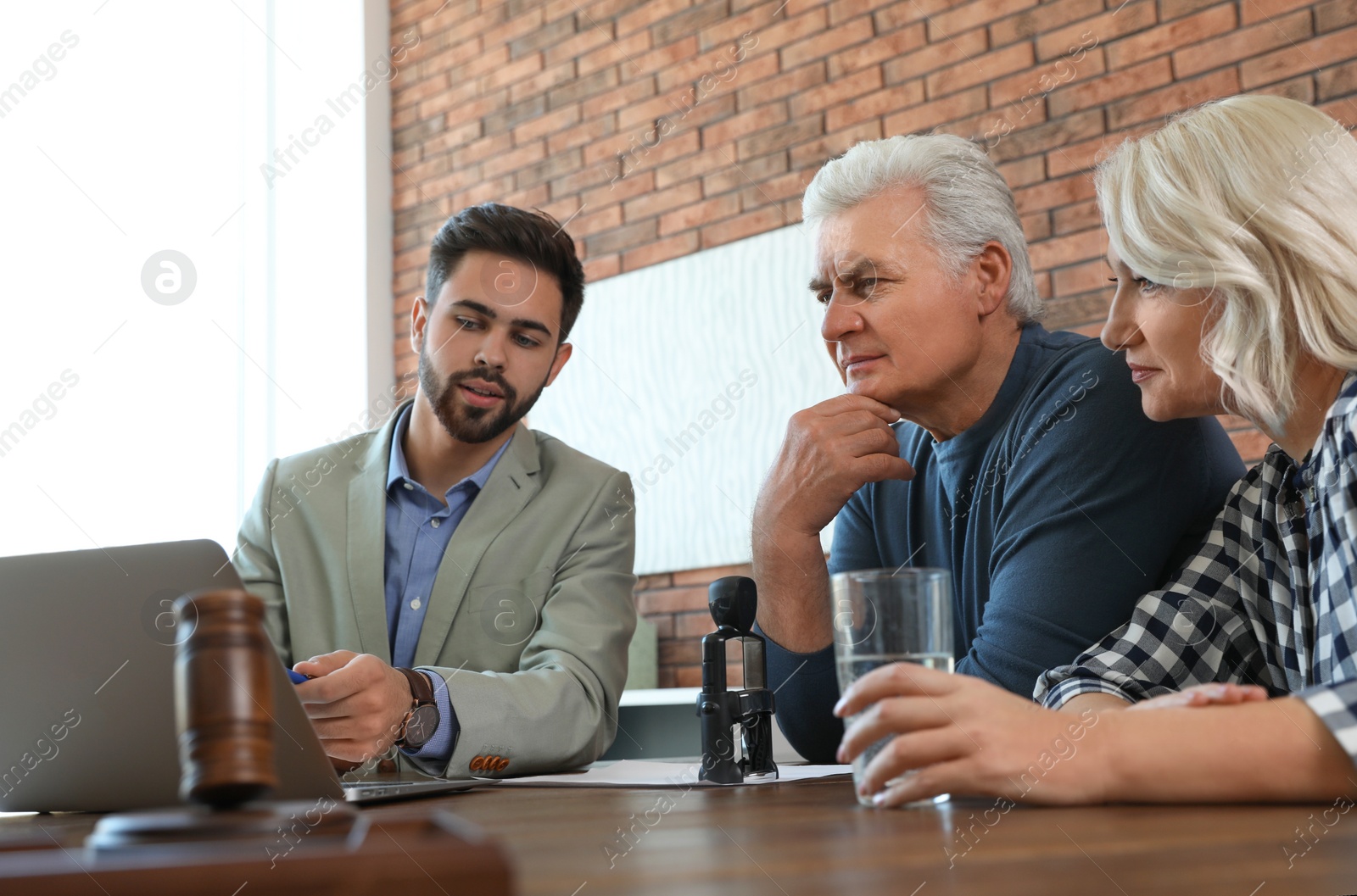 Photo of Male notary working with mature couple in office