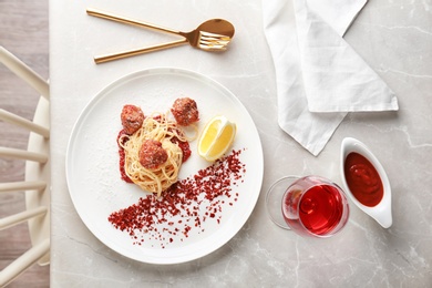 Delicious pasta with meatballs and tomato sauce on table, top view