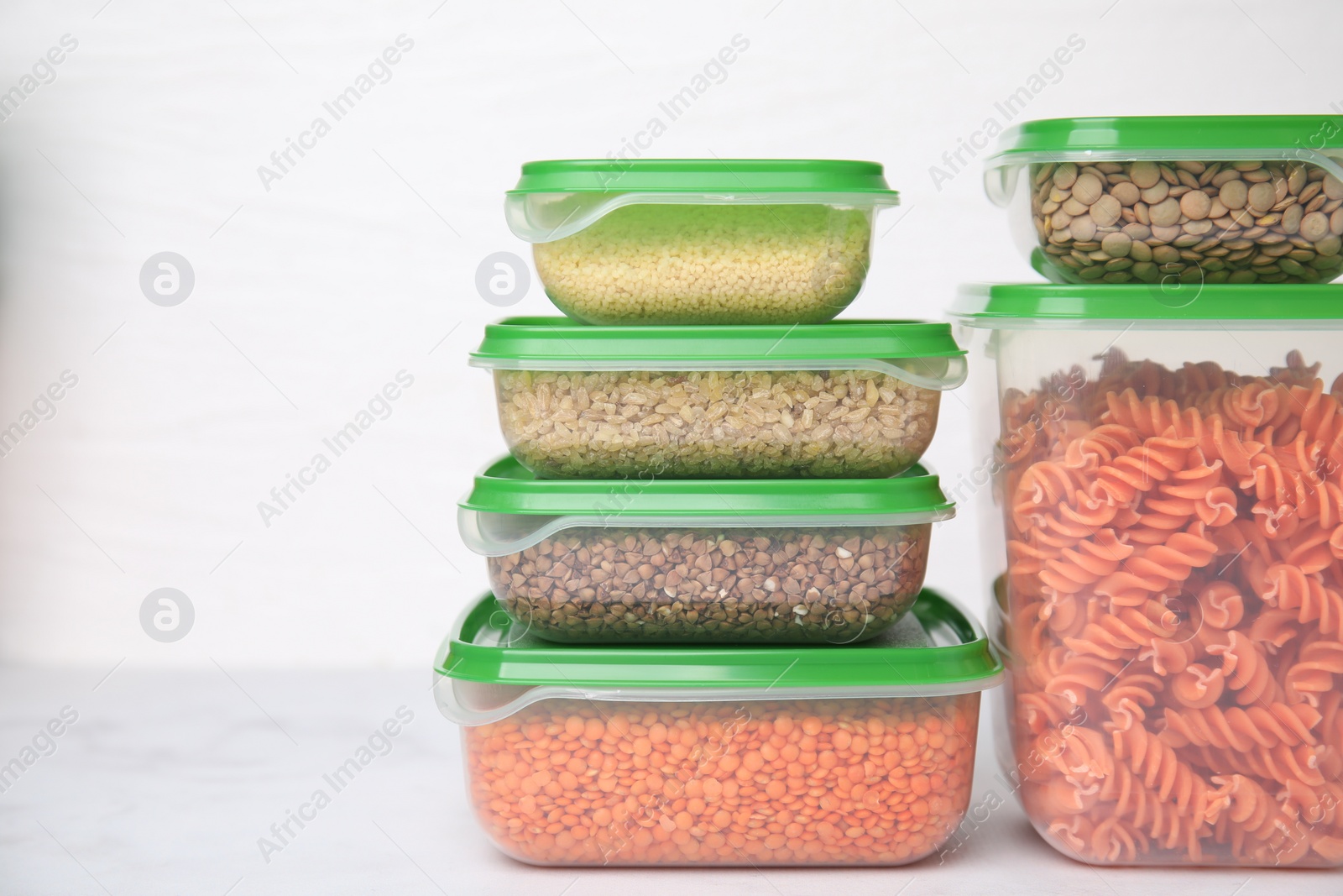 Photo of Plastic containers filled with food products on white table. Space for text