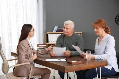 Young lawyer consulting senior couple in office