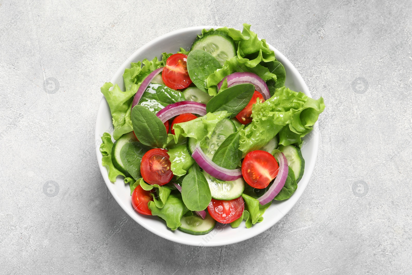 Photo of Delicious vegetable salad on light grey table, top view