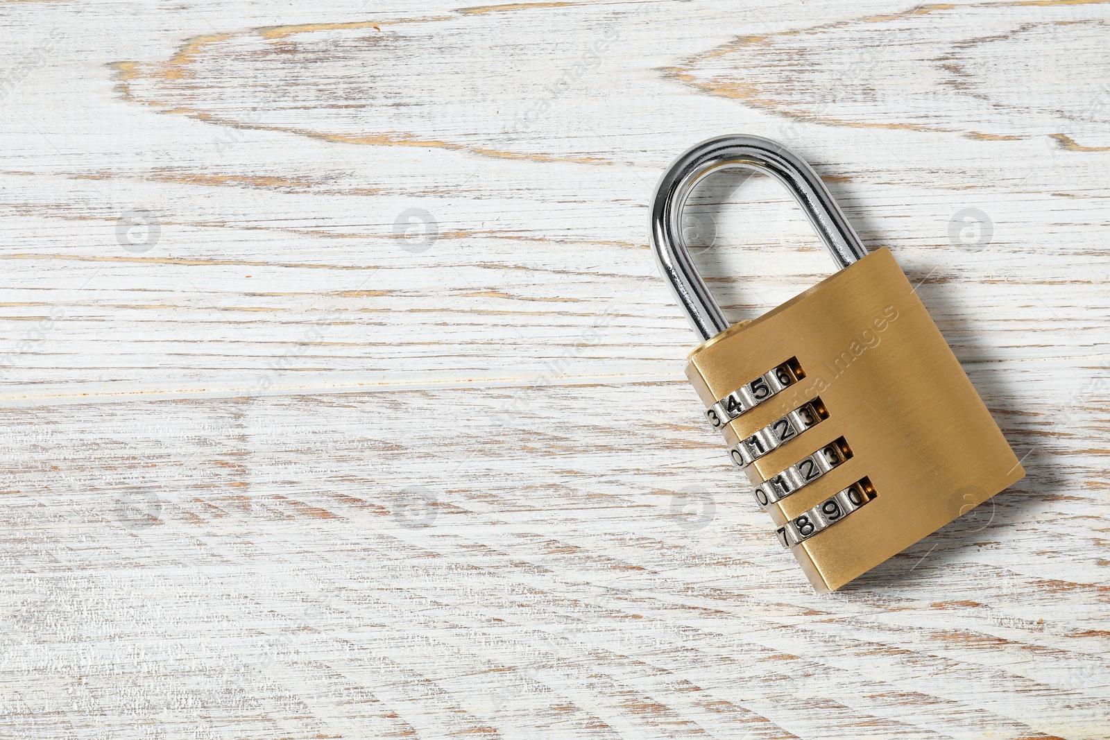 Photo of One steel combination padlock on white wooden table, top view. Space for text