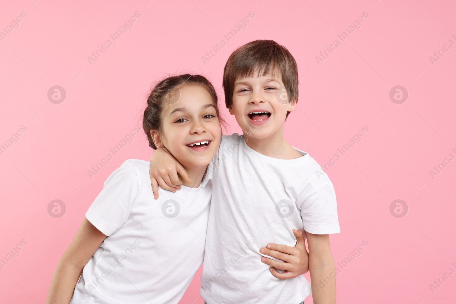 Photo of Happy brother and sister on pink background