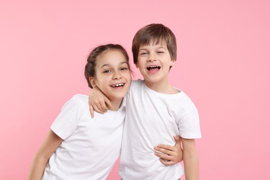 Happy brother and sister on pink background