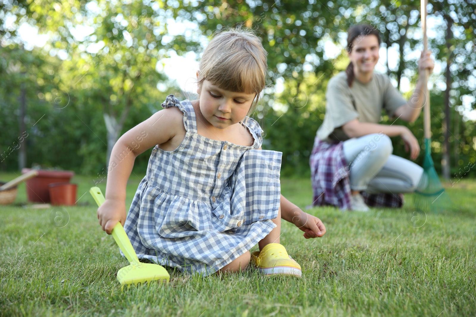 Photo of Mother and her daughter working together in garden