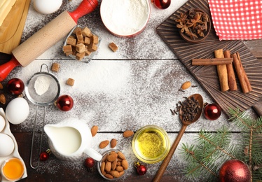 Photo of Flat lay composition with ingredients for traditional Christmas cake on wooden table. Space for text