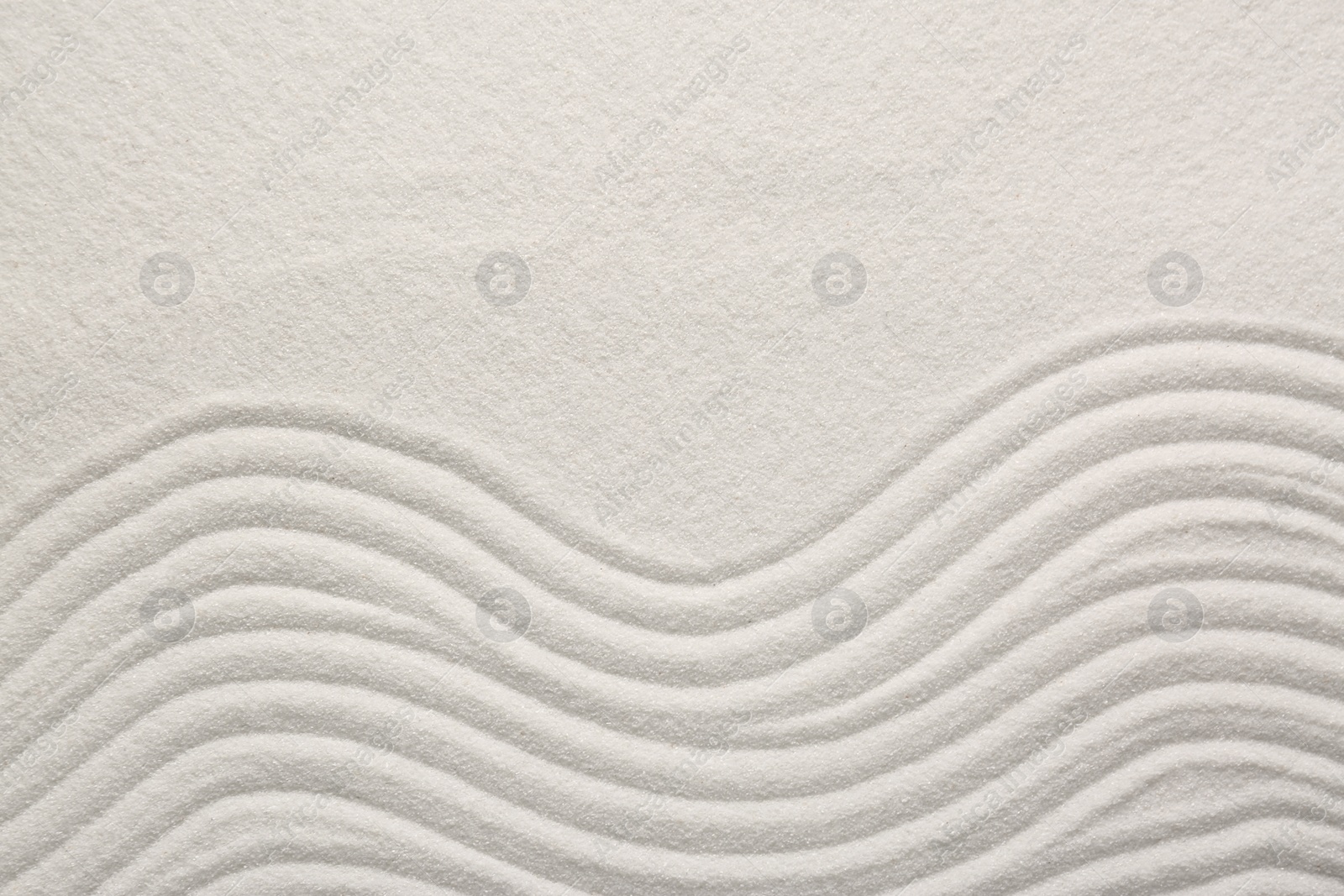 Photo of White sand with pattern as background, top view. Zen concept