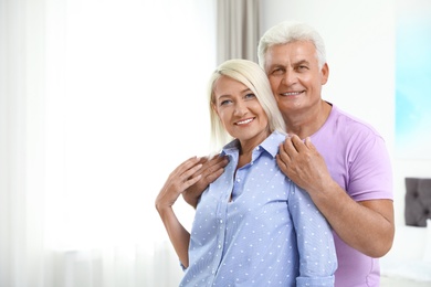 Photo of Portrait of happy senior couple at home. Space for text