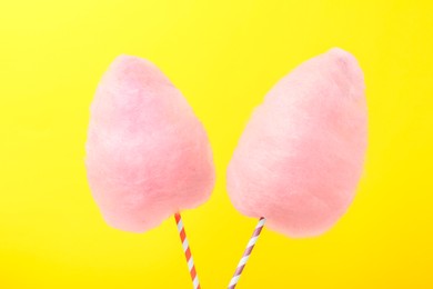 Photo of Two sweet pink cotton candies on yellow background