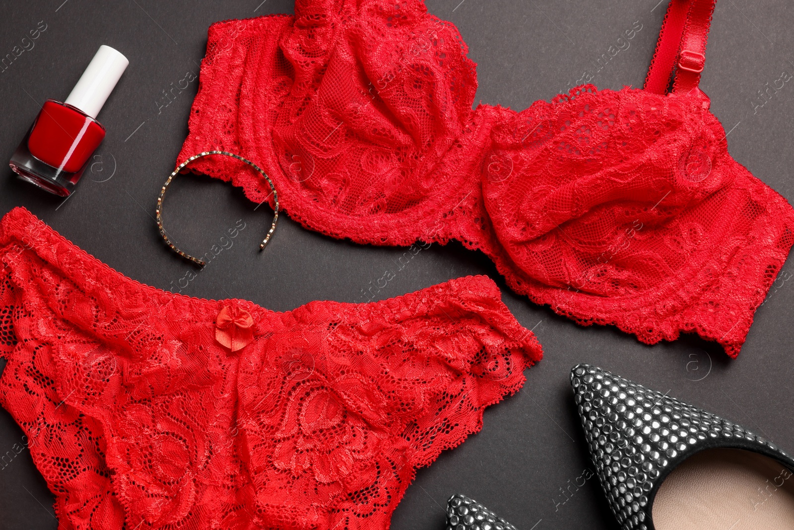 Photo of Composition with red women's underwear and shoes on dark grey background, closeup