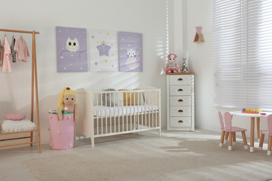 Photo of Baby room interior with cute posters and crib