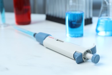 Photo of Laboratory analysis. Micropipette with liquid on white table, closeup