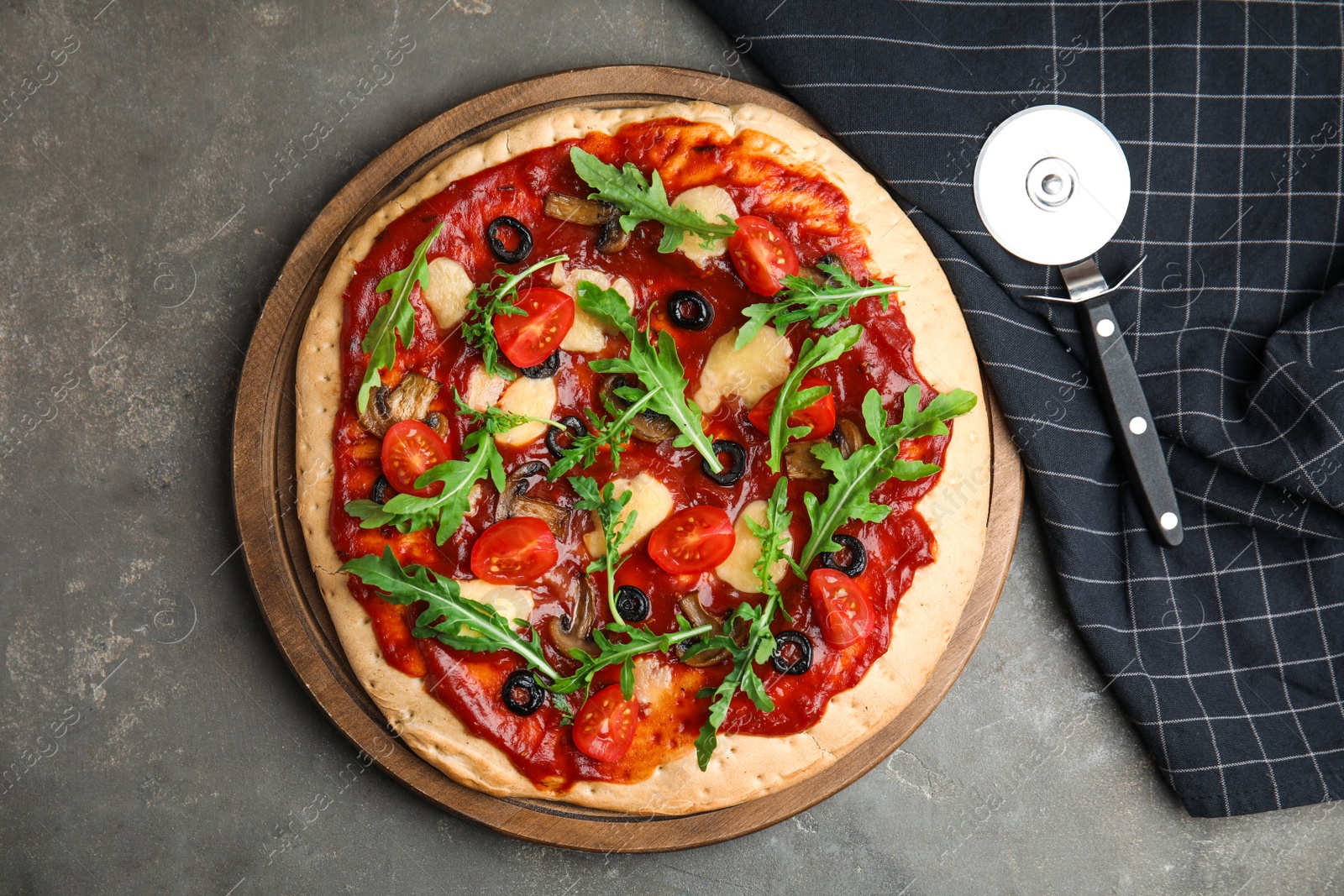 Photo of Pita pizza with cheese, olives, tomatoes and arugula on grey table, flat lay