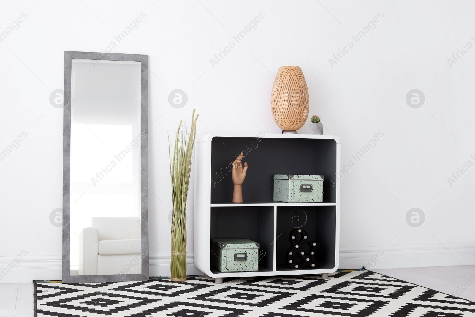 Photo of Elegant room interior with large mirror and shelving unit