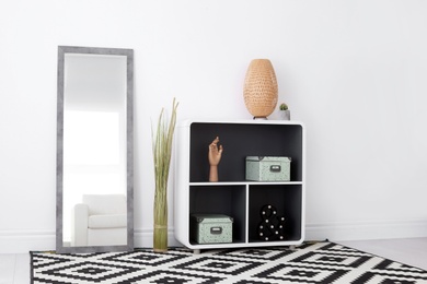 Elegant room interior with large mirror and shelving unit