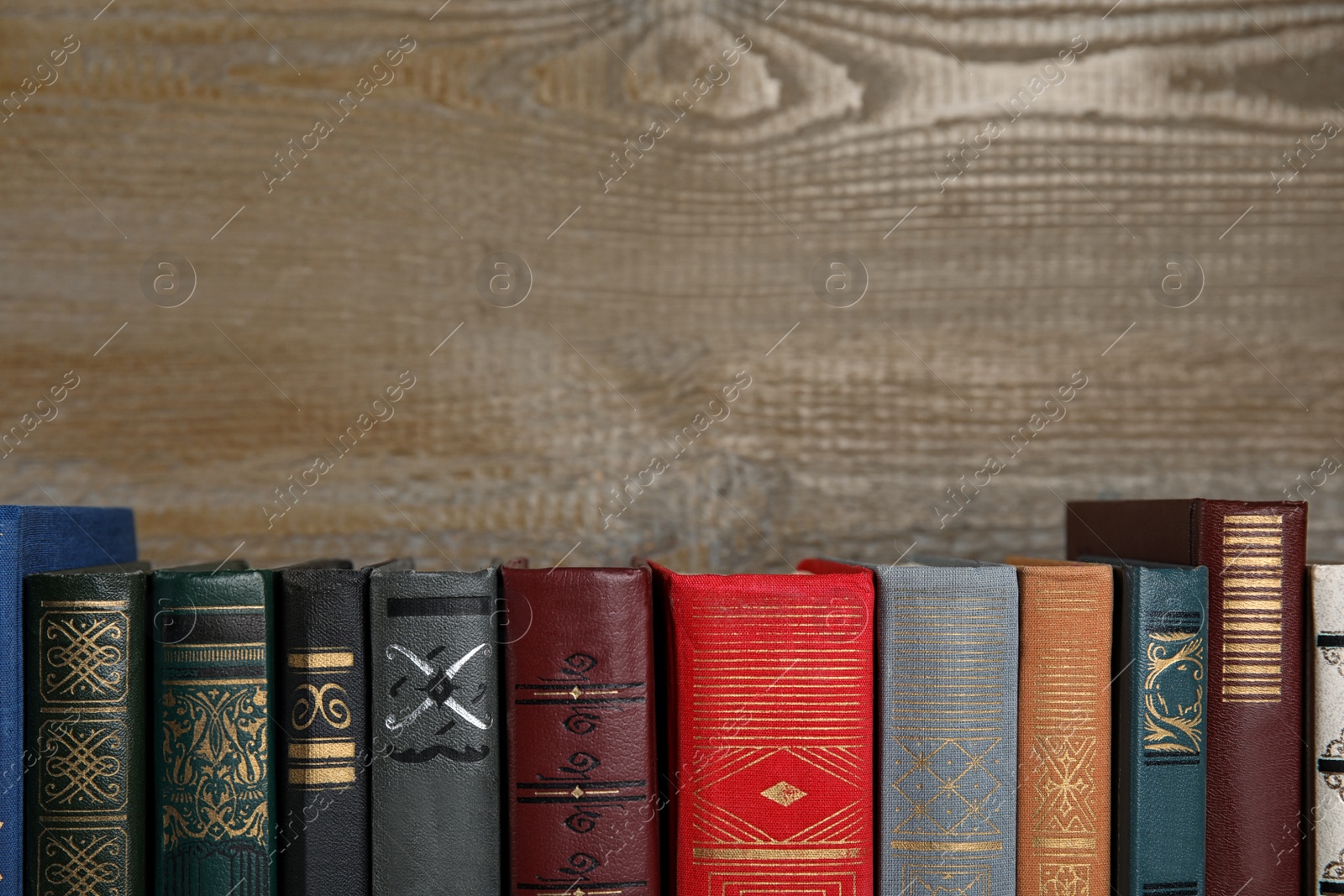 Photo of Stack of hardcover books on wooden background. Space for text