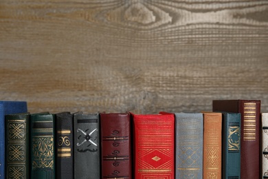 Stack of hardcover books on wooden background. Space for text