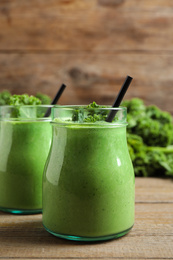 Tasty fresh kale smoothie on wooden table