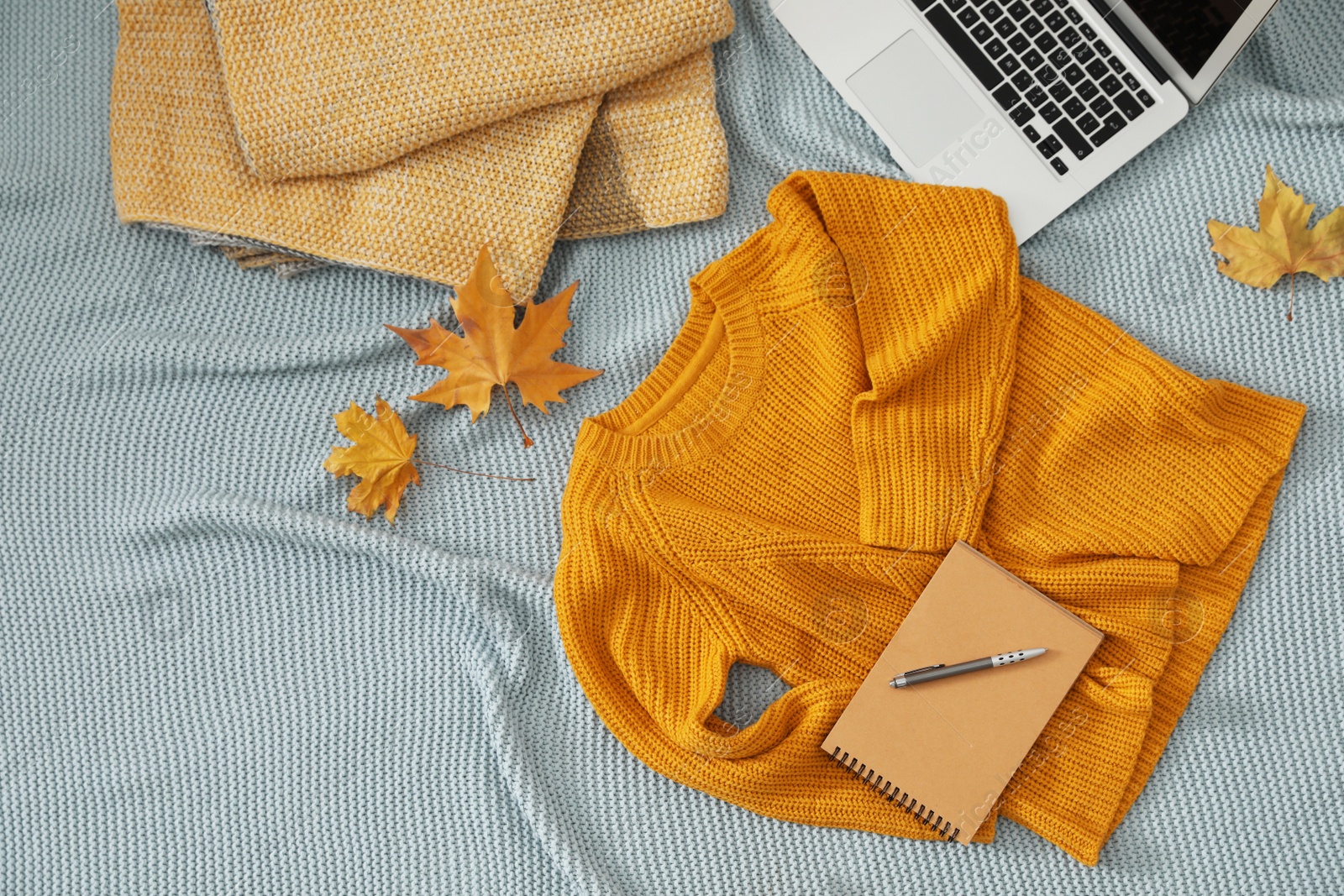 Photo of Flat lay composition with cozy knitted sweater on blanket. Space for text