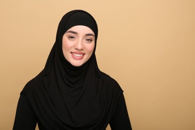 Photo of Portrait of Muslim woman in hijab on beige background. Space for text