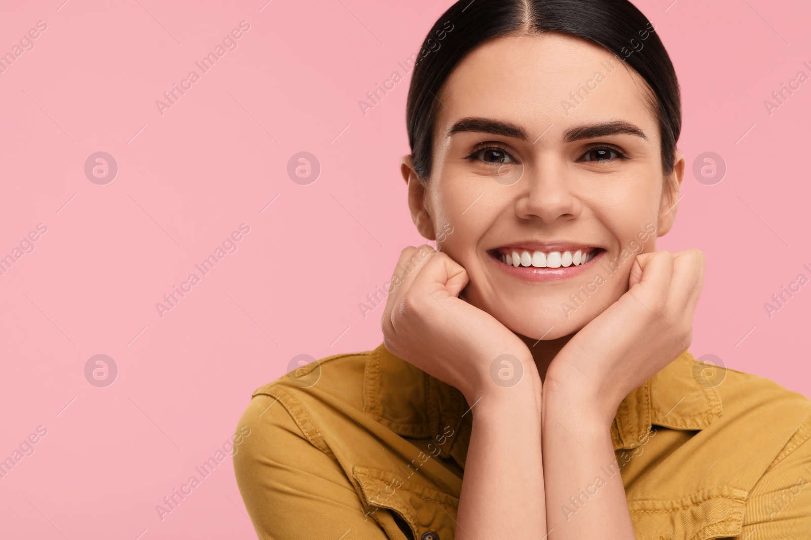 Photo of Young woman with clean teeth smiling on pink background, space for text