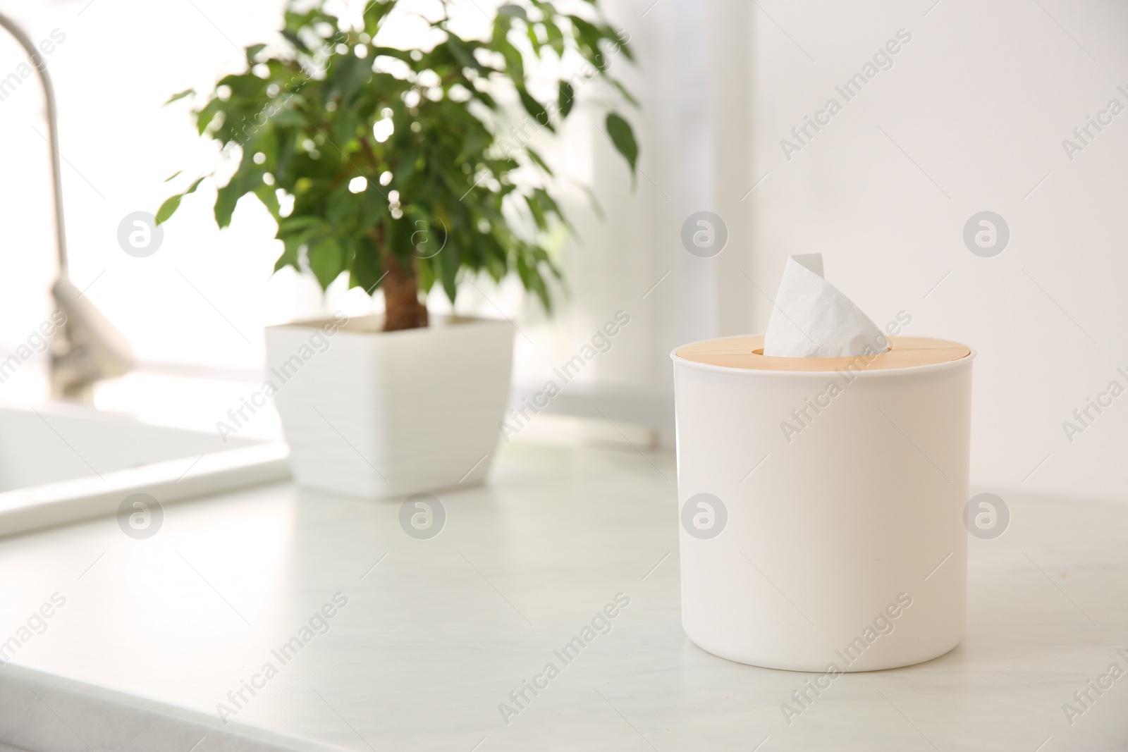 Photo of Box with paper tissues on white countertop in kitchen. Space for text