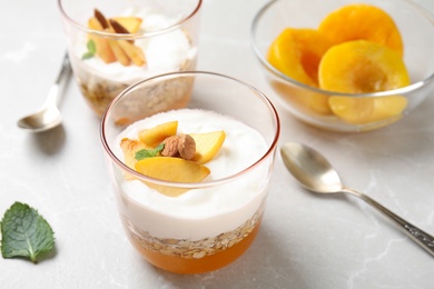 Tasty peach dessert with yogurt and granola served on light table