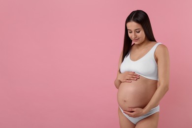 Beautiful pregnant woman in stylish comfortable underwear on pink background, space for text