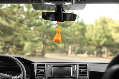 Photo of Air freshener hanging on rear view mirror in car