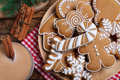 Photo of Delicious gingerbread Christmas cookies on wooden table, flat lay